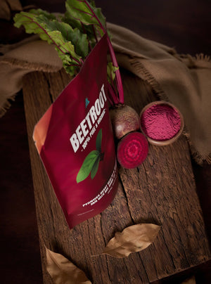 Red bag labeled 'Beetroot' with beetroot root and powder on a wooden surface