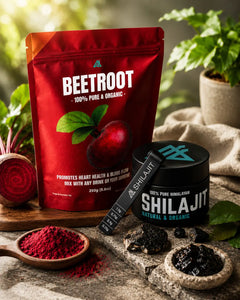 Red package of organic beetroot powder and black container of Shilajit on a wooden surface with plants in the background.