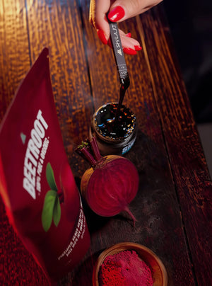 Beetroot powder packaging with a spoonful of powder on a wooden surface