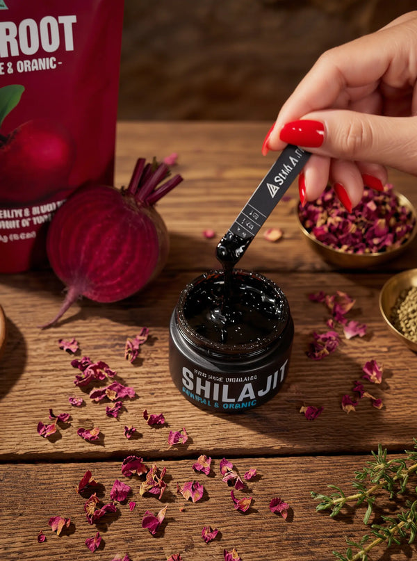 Person using a Shilajit stick to extract liquid from a container on a wooden surface with beetroot and dried flowers.